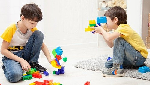 Siblings play Lego