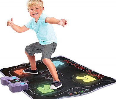 A boy is very happy on the dance mat.